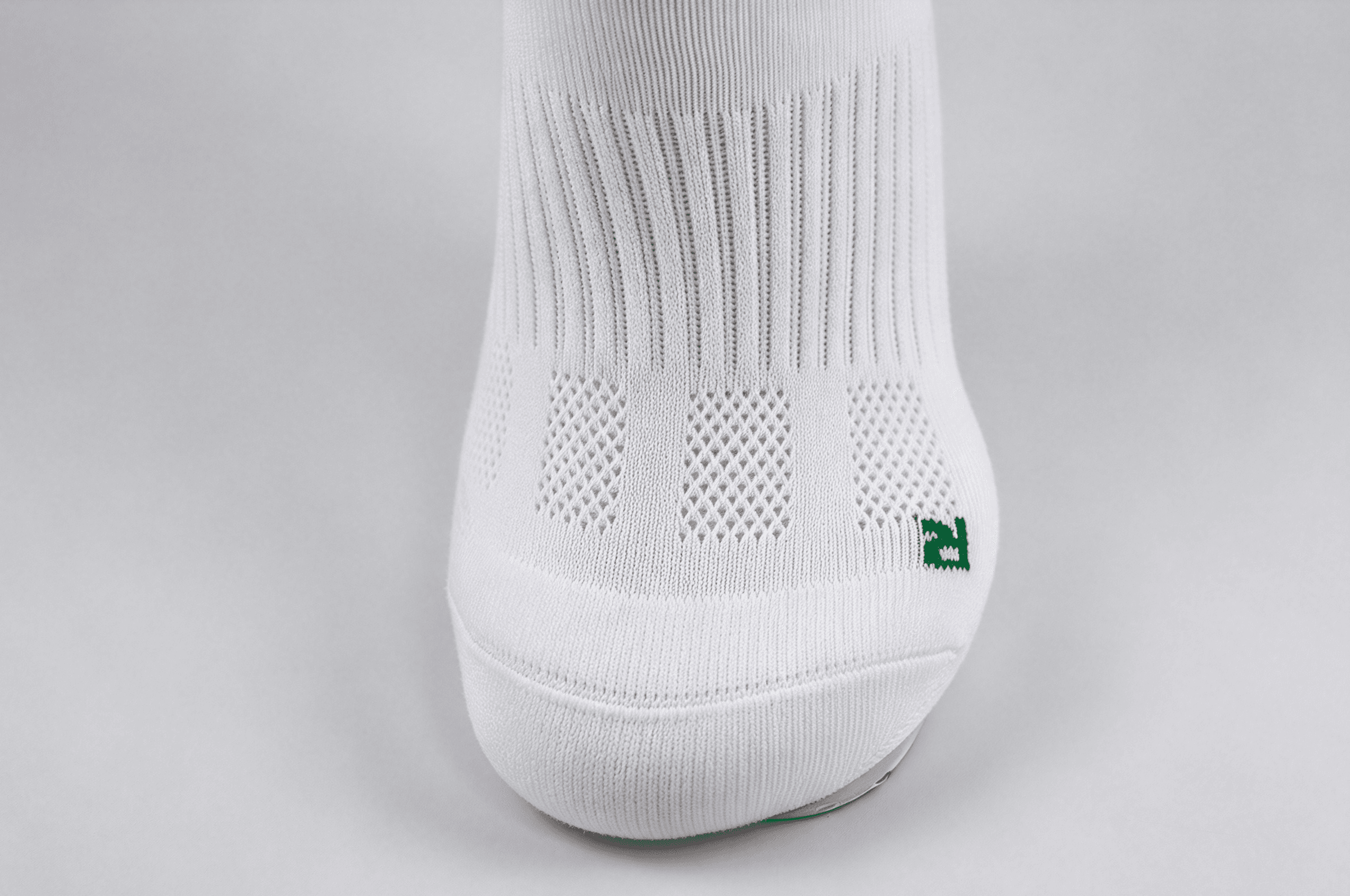 Close-up of ventilation mesh on a white running sock