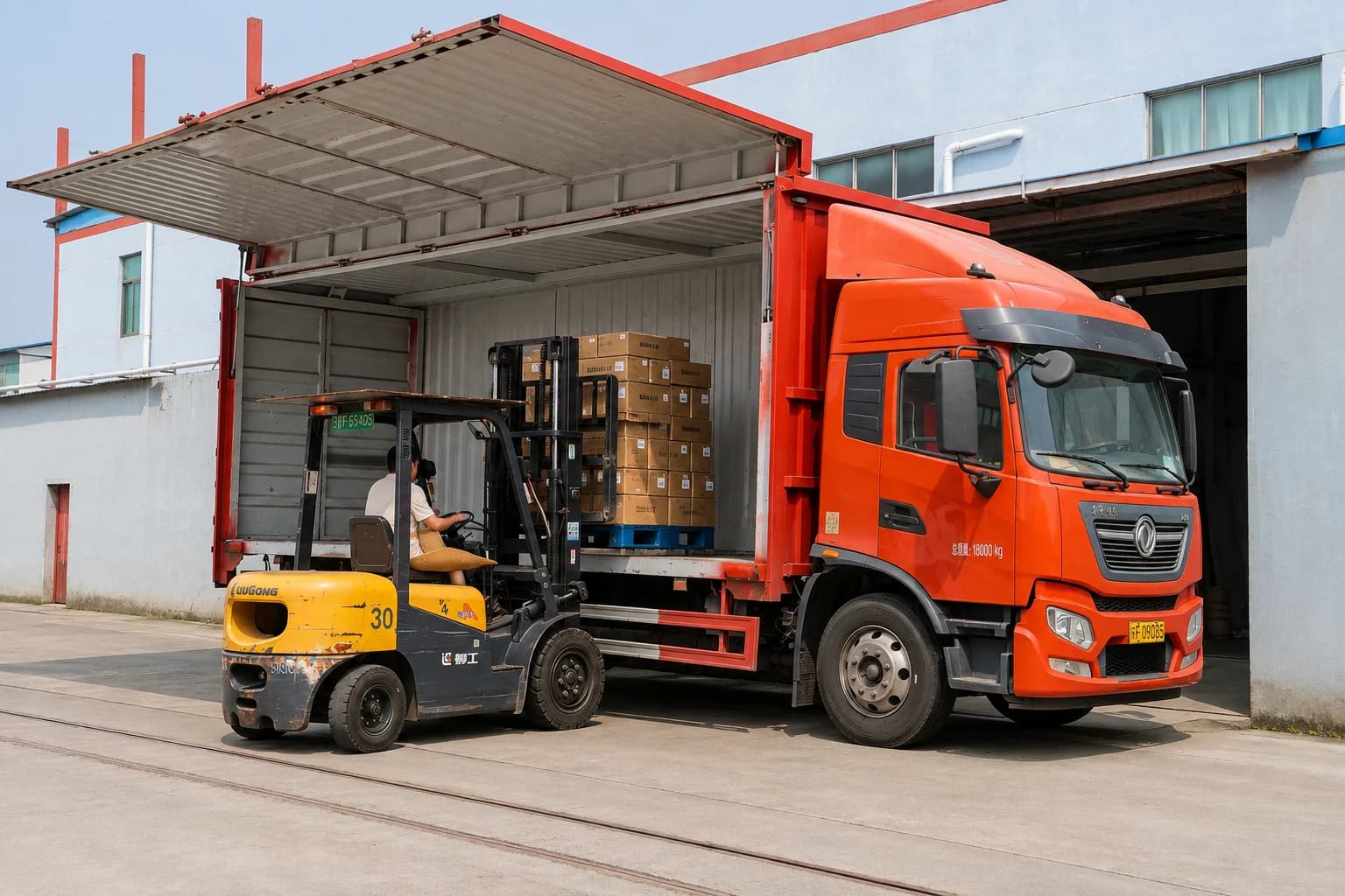 Forklift loading pallets of sock cartons onto a truck outside the factory