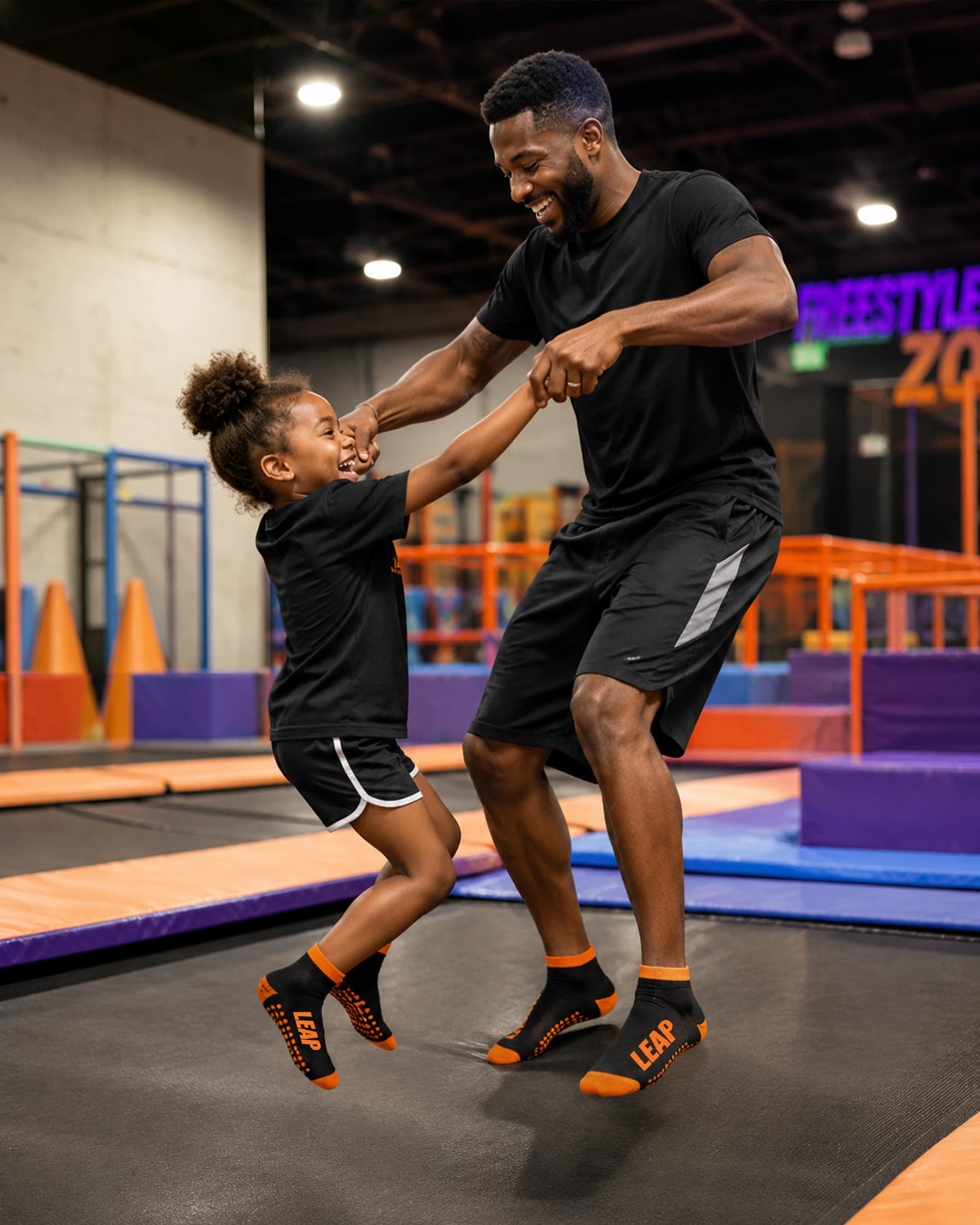 Adult and child wearing branded grip socks in an indoor activity center