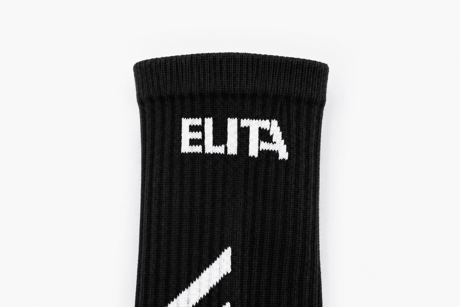 Close-up knitted studio name on the cuff of a black Pilates sock