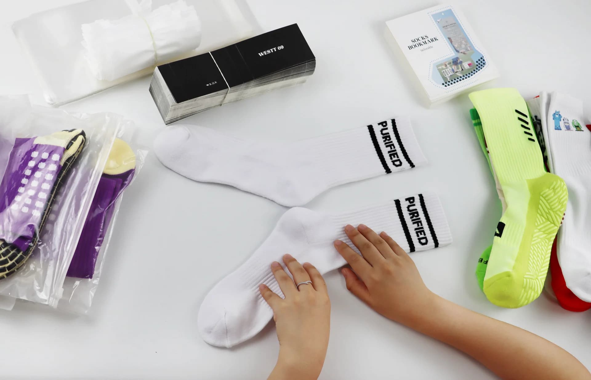Factory team reviewing a private label sock sample beside product and packaging components
