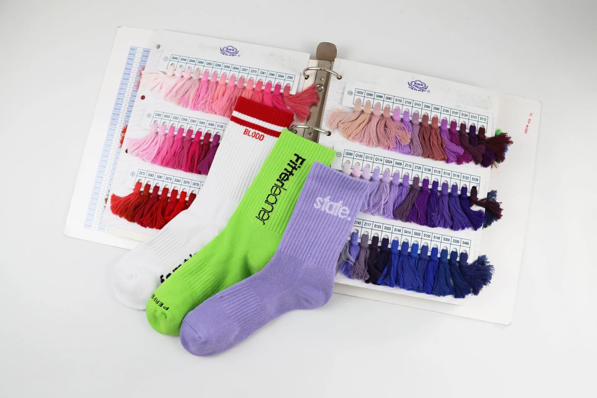 Private label sock sample styles arranged with yarn color swatches for sampling review