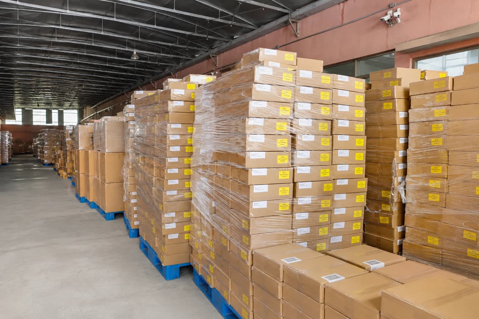 Wrapped pallets of labeled sock cartons arranged inside the dispatch warehouse